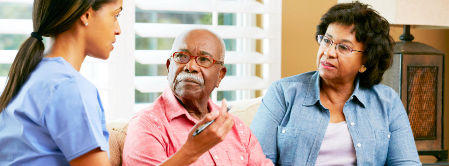 senior couple talking with caregiver